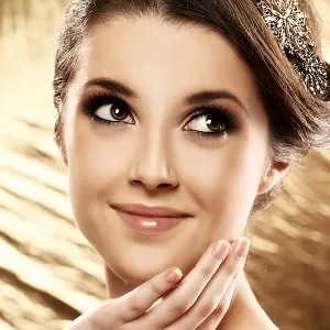Femme à la peau éclatante, mains sur le visage – soins du visage